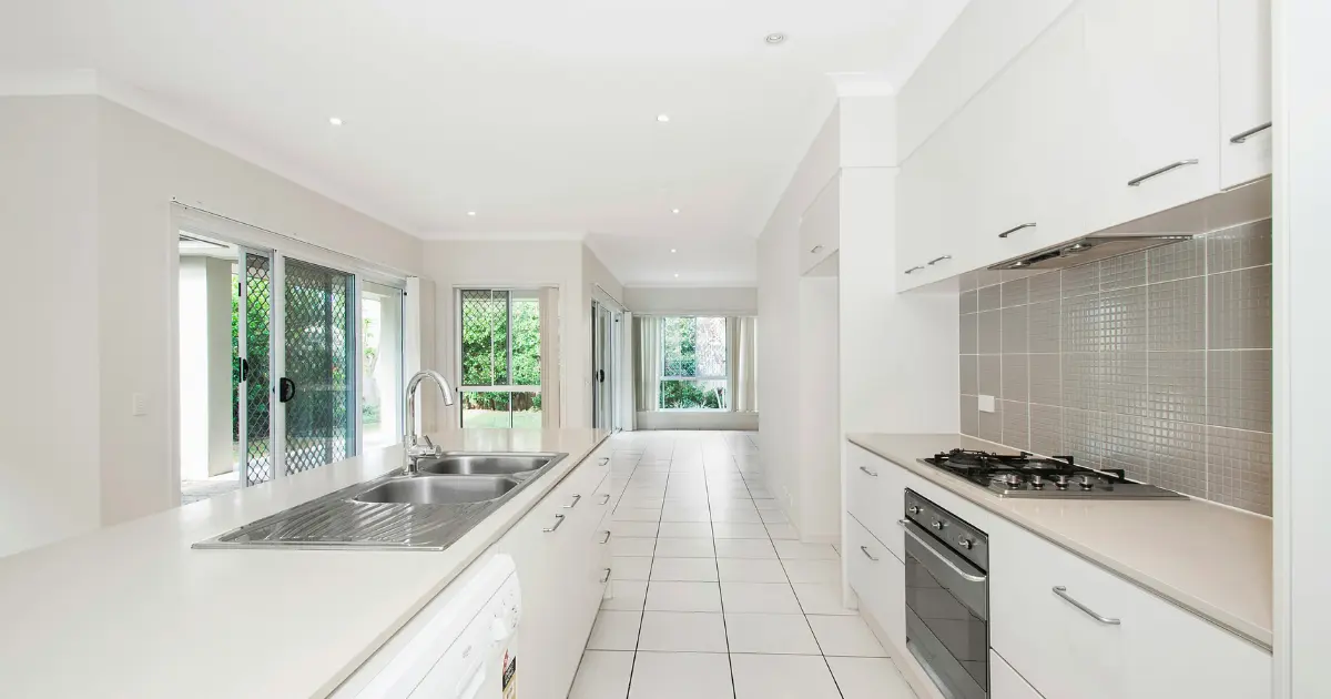 Cocina moderna y luminosa en una vivienda recién construida, ejemplo de los acabados que influyen en el precio por metro cuadrado de construcción en España.