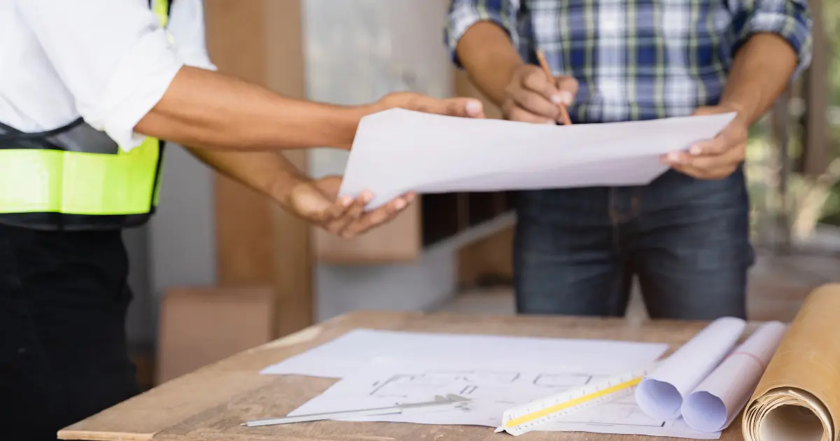Técnicos de construcción revisando planos y documentación técnica antes de firmar la orden de inicio de obra