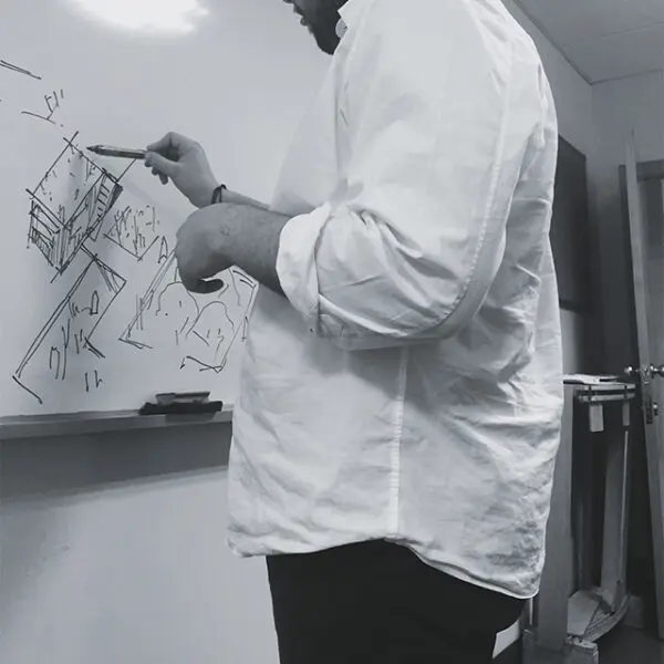 Arquitecto dibujando croquis en pizarra durante fase de diseño conceptual