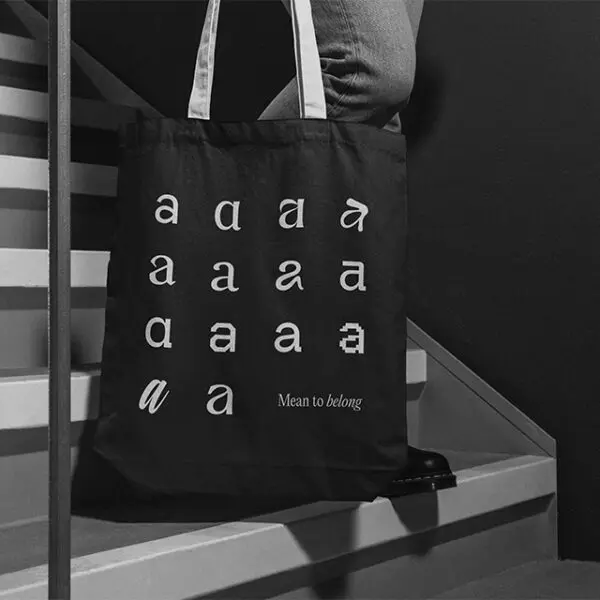 Bolsa de tela con diseño tipográfico en entorno arquitectónico contemporáneo