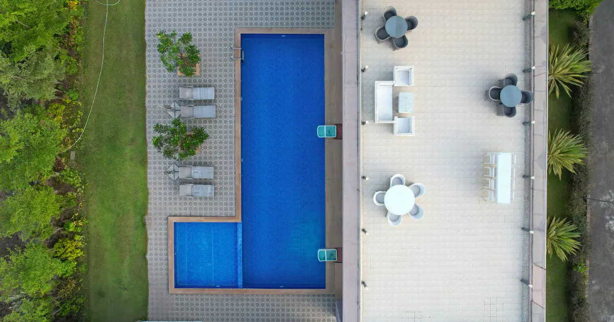 Vista aérea de un chalet con piscina y jardín privado, rodeado por muros perimetrales que deben respetar la altura máxima permitida por la normativa municipal.